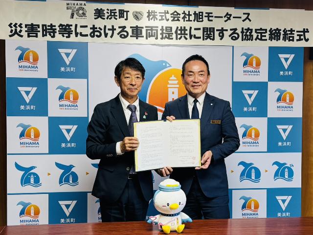 旭日モータース様と災害時等における車両提供に関する協定書を締結した際、町長と代表が協定書を持ち並んで写真を撮っている様子