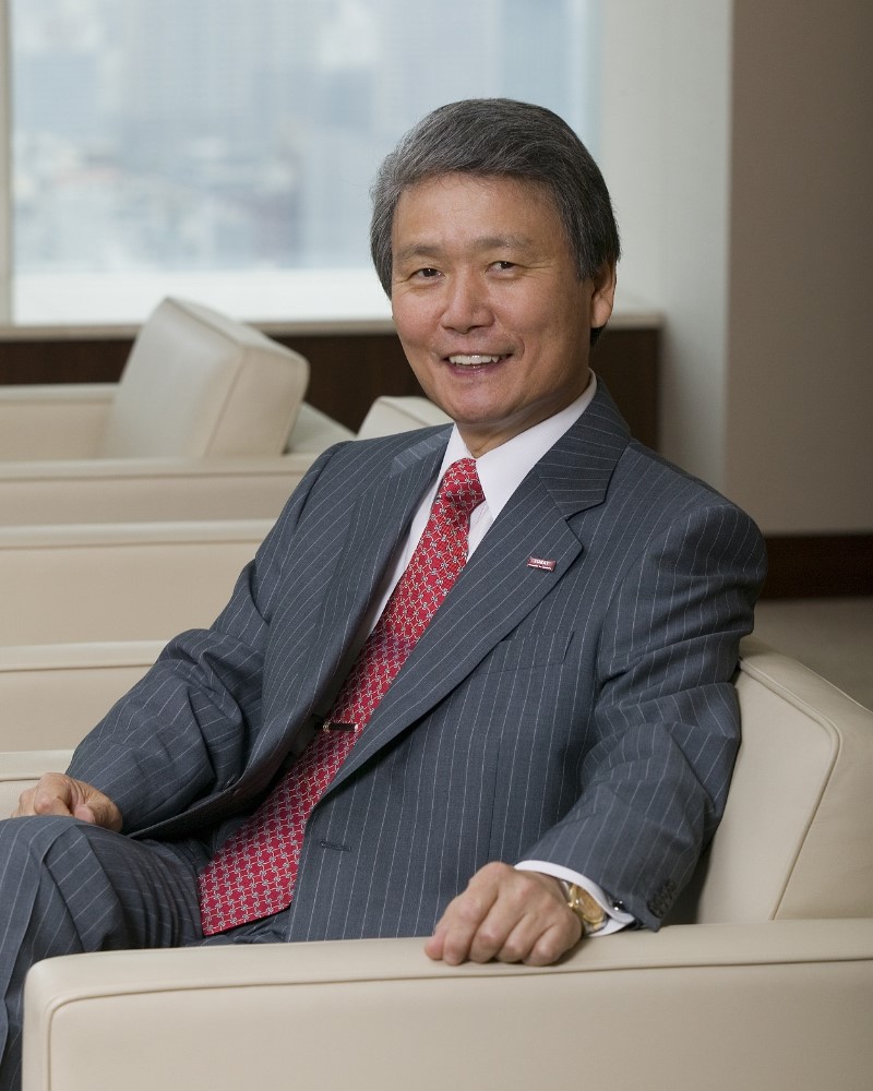 ベージュのソファーにスーツ姿で座っている榊原定征氏の写真