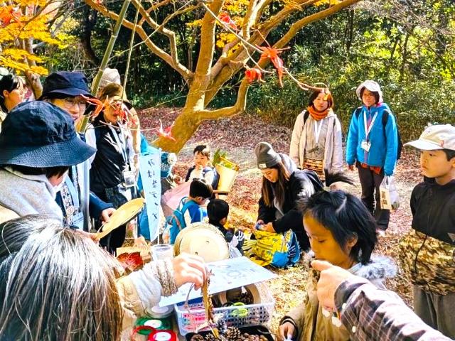 里山を楽しむOrangeDayで参加者が松ぼっくりなどを使って作品作りをしている様子