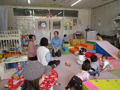 玩具で遊んでいる乳幼児と親子が写っている親子交流スペースでの写真
