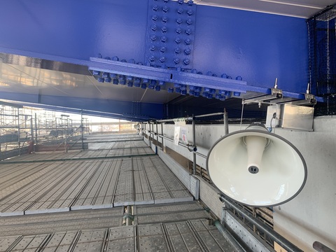 陸上競技場観覧スタンド屋根の壁側部分に取り付けられたスピーカーの写真