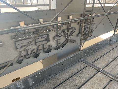 銀色で施された「競技場」の文字が、陸上競技場観覧スタンド外壁部分に取り付けられた写真