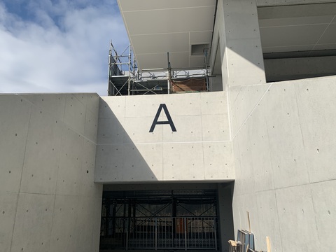 入口上部分に黒色でアルファベットのAの文字が取り付けられた陸上競技場観覧スタンド出入り口ゲートの写真