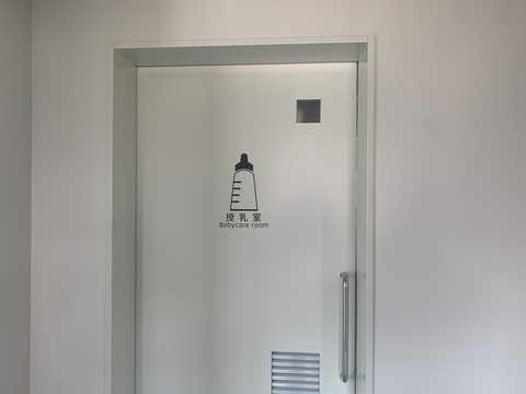 引き戸の中央上部に哺乳瓶のピクトグラムと「授乳室Baby room」と書かれたサインが取り付けられた写真