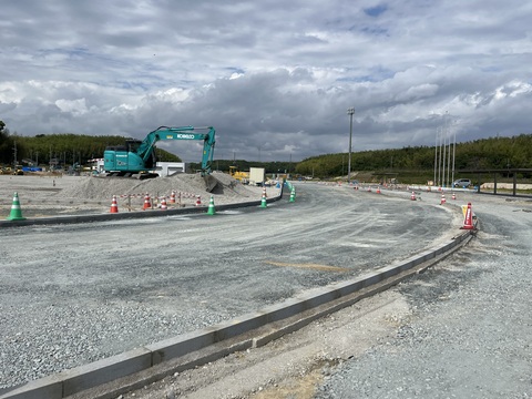 フィールド内の砂山で水色の工事車両が作業を行っているなか、トラック部分の路床整正の工事が行われ地面が均一にならされた写真