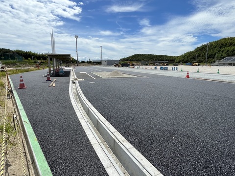 砂場を避けて路盤工事が行われた東屋の前の真っすぐに伸びたアウトフィールドの上から基層工事が行われている様子の写真