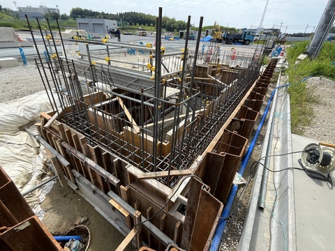 建設予定地の写真判定室棟の中に設置された鉄筋の中に板が組み込まれている型枠設置工事の様子写真