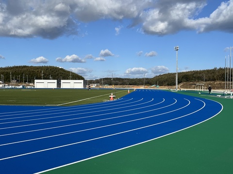 奥に器具庫が建っているのが見える右側にカーブしたトラック部分に、白色のラインが引かれている写真