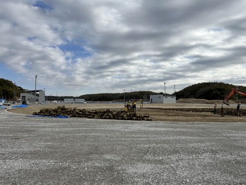工事予定地の交流広場に沢山の芝が置かれている芝敷設工事の様子の写真