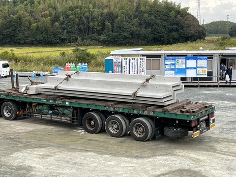 大きなトラックの荷台に3枚の段床版が積まれて運ばれてきた様子を撮影した写真