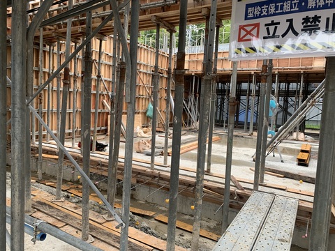 周囲に足場が組まれた陸上競技場観覧スタンド1階部分の中央で型枠設置工事が行われている様子をアップで撮影した写真
