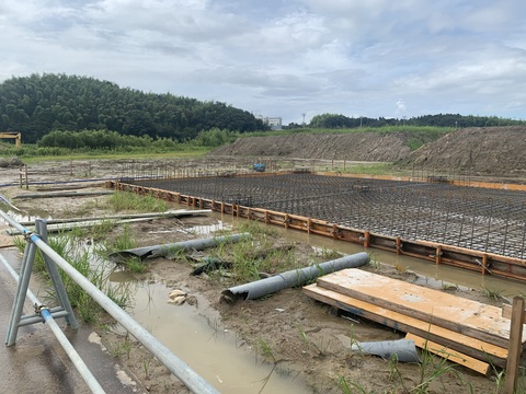 木枠で囲まれた陸上競技場器具庫の建設現場で、床部分の配筋工事が行われている様子の写真