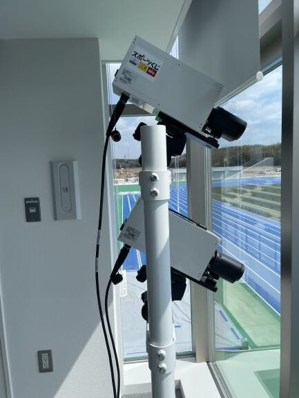 「totoスポーツくじロゴ」のステッカーが貼られた写真判定装置が窓際に設置され、ステッカー部分がわかるようにアップで写された写真