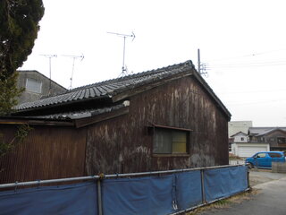 鉄筋やネットで囲ま間れた瓦屋根のこげ茶色の木造平屋建ての河和-13外観写真
