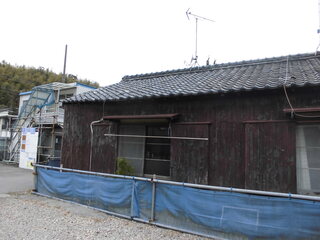 鉄筋やネットで囲ま間れた瓦屋根のこげ茶色の木造平屋建ての河和-12外観写真