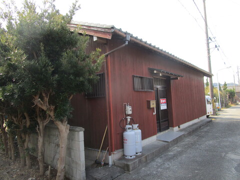 屋根瓦で茶色の外壁の平屋建ての物件を玄関側から写した外観写真