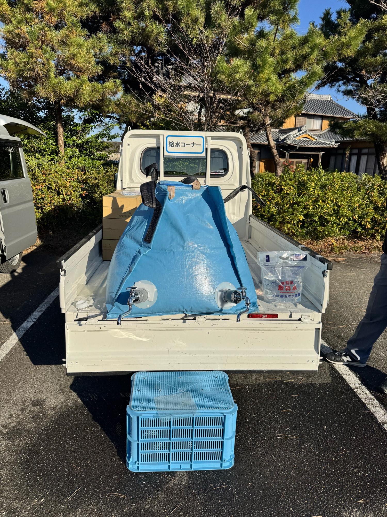 軽トラックの荷台部分に簡易給水槽を積んでいる写真