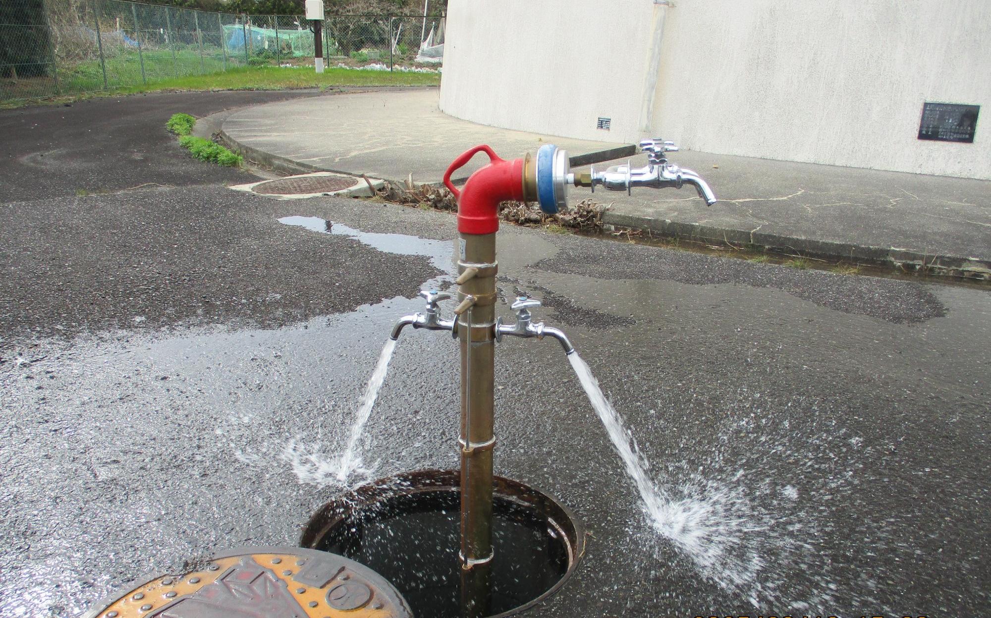 消火栓に、2つの蛇口が付いた専用器具と2つの蛇口が付いた給水栓を接続した写真