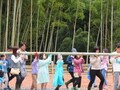 参加者たちが1本の長い竹を肩に担いで運んでいる写真