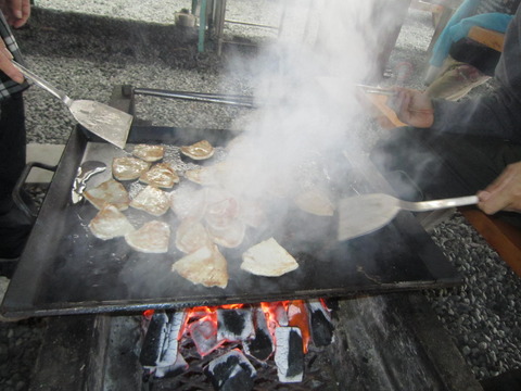 食材が乗った鉄板から勢いよく湯気が立ちのぼり、両側からフライ返しを持った手が伸びている写真
