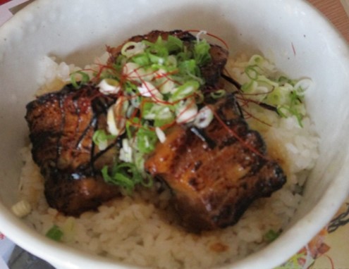 白い器にご飯が盛られ、その上には香ばしく焼かれた恋美豚炙り、ネギがちらされた恋美豚炙り丼を上から写した写真