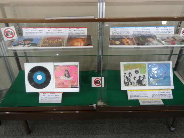 レコードジャケットの見開きや表紙がショーケース内に2段になって展示されている写真