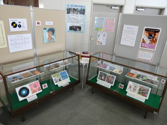 ショーケースとパーテーションそれぞれにレコードジャケットや説明文が複数展示されている写真