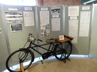 パーテーションの前に黒い昔の自転車が展示されている写真