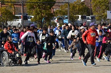 老若男女問わずゼッケンを胸元の位置に貼った参加者たちがグラウンドを走っている様子の写真