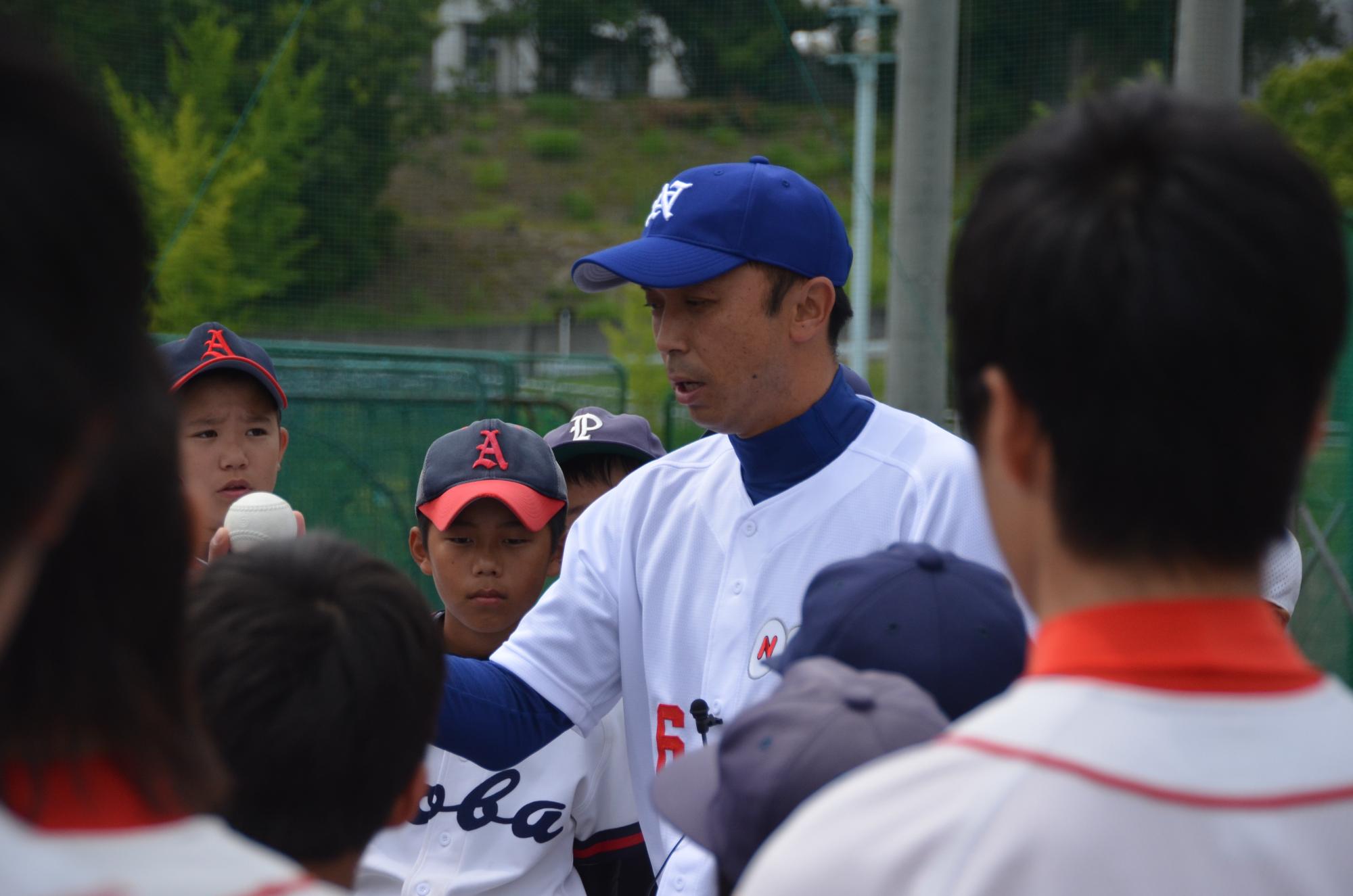 参加した子供達がボールを握る宮本選手の説明を真剣な表情で聞いている写真
